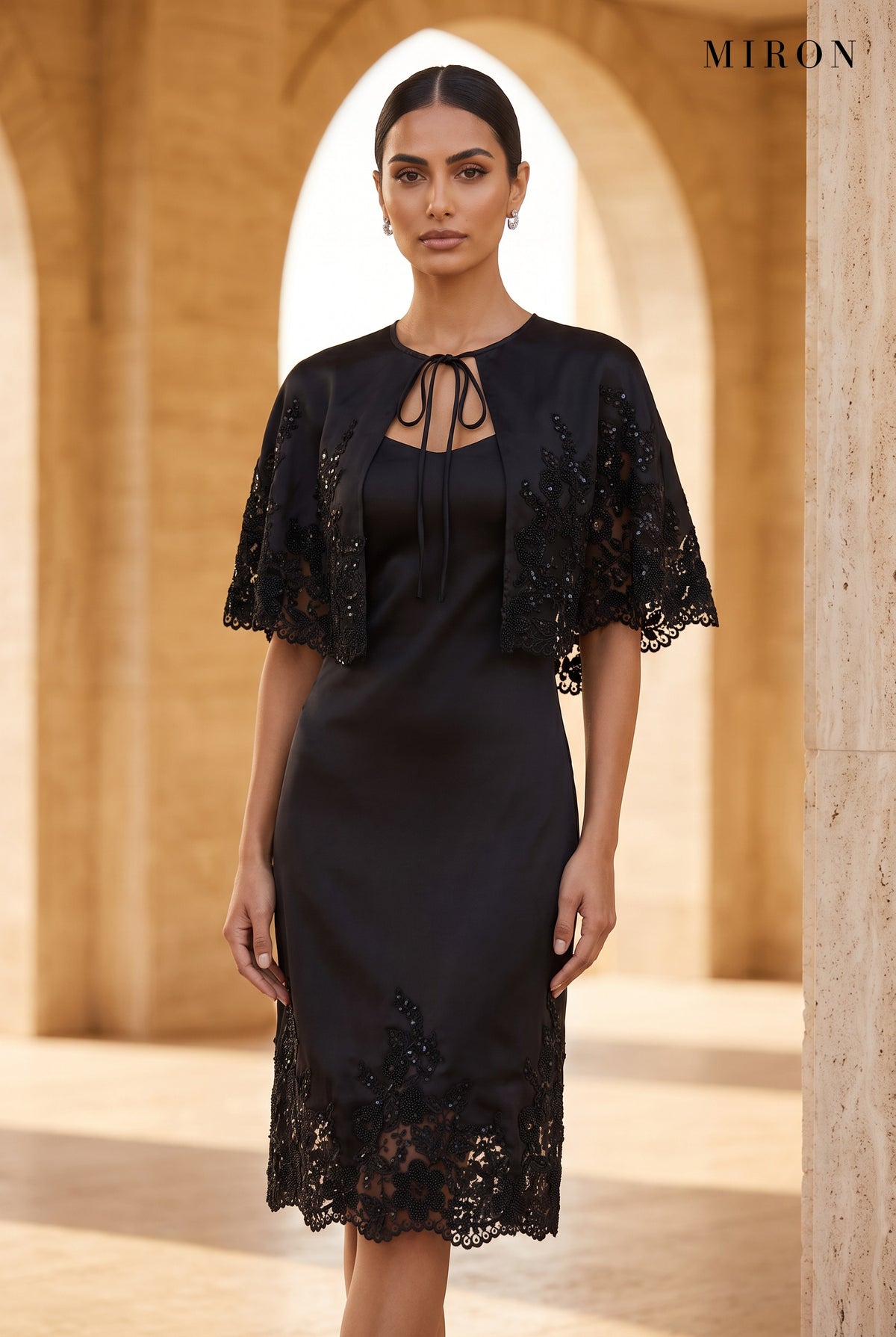 Black Lace Cape Dress – worn by model, travertine setting